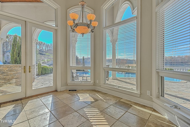 doorway to outside with a chandelier and french doors