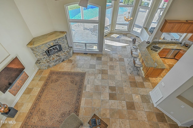 living room with a fireplace, a towering ceiling, and sink