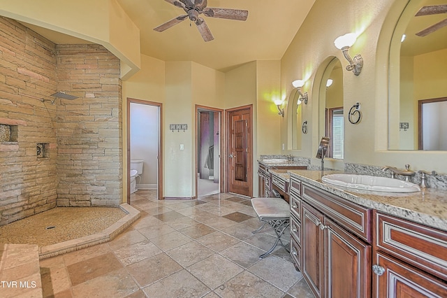 bathroom with a shower, ceiling fan, vanity, and toilet