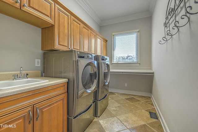 laundry area with washer and clothes dryer, crown molding, cabinets, and sink