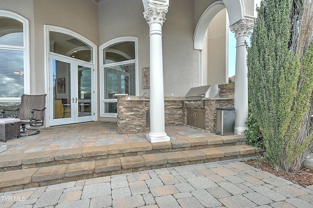 view of patio / terrace featuring french doors, sink, grilling area, and exterior kitchen