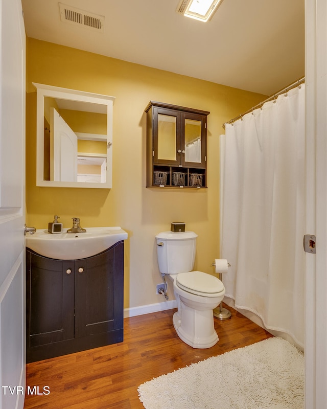 bathroom with wood-type flooring, toilet, and vanity