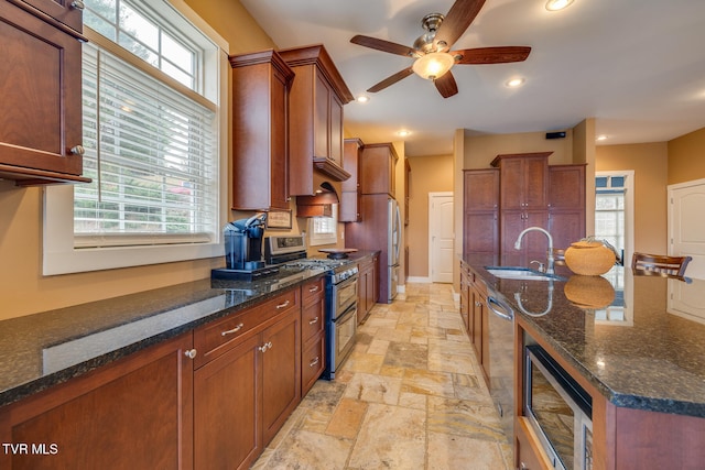 kitchen with appliances with stainless steel finishes, sink, and dark stone countertops