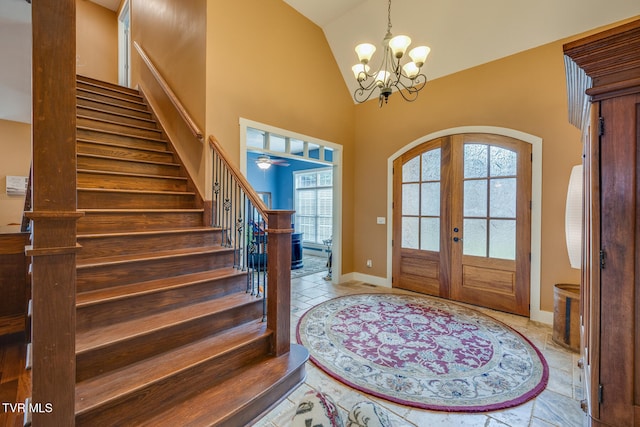 foyer entrance featuring french doors, high vaulted ceiling, and an inviting chandelier