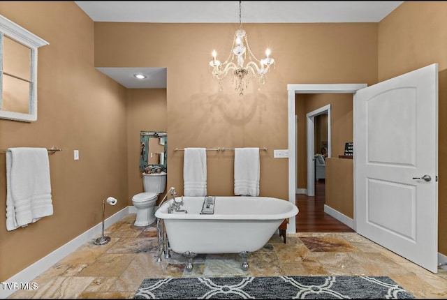 bathroom featuring an inviting chandelier, toilet, and a bathing tub