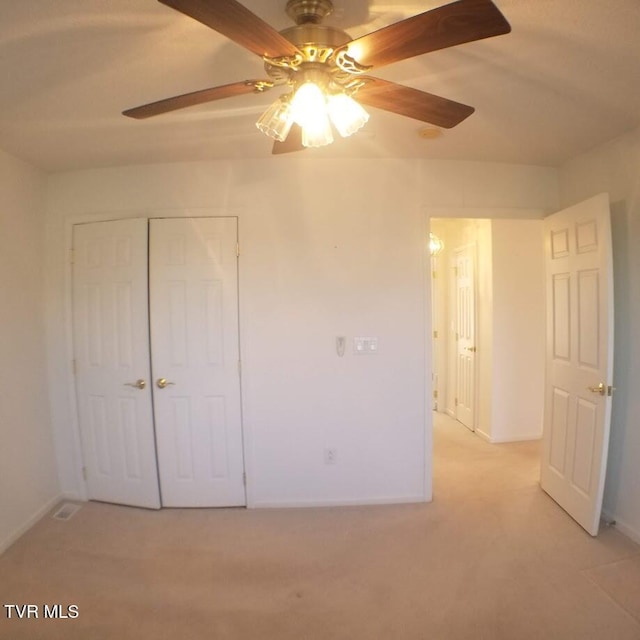 unfurnished bedroom with ceiling fan, light colored carpet, and a closet