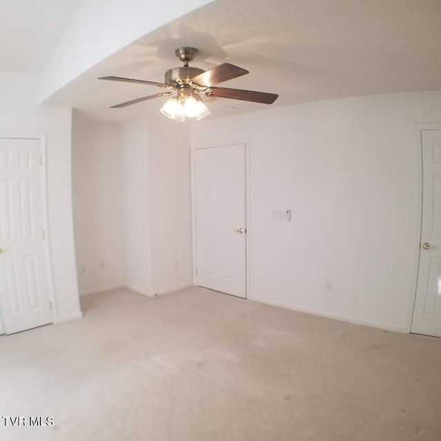 carpeted spare room with ceiling fan