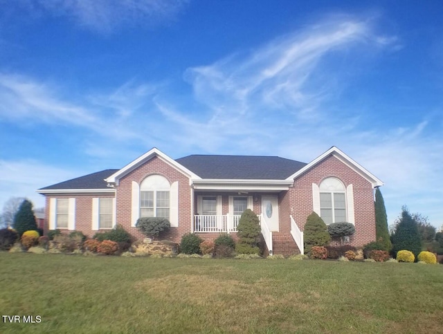 ranch-style home featuring covered porch and a front lawn