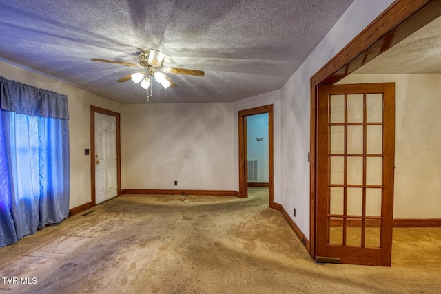 empty room featuring light carpet, a textured ceiling, and ceiling fan