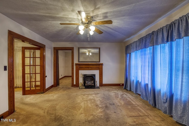 unfurnished living room featuring ceiling fan, light colored carpet, and a textured ceiling