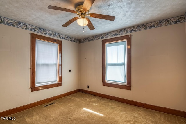 empty room with light carpet, a textured ceiling, and ceiling fan