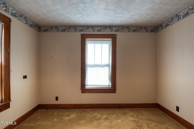 spare room with a textured ceiling and light colored carpet