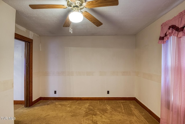 unfurnished room featuring ceiling fan, light colored carpet, and a textured ceiling