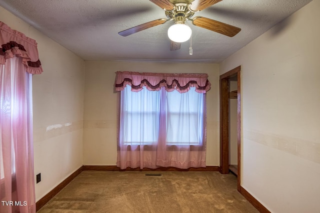 carpeted spare room with a textured ceiling and ceiling fan