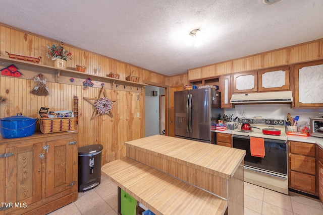 kitchen with a textured ceiling, light tile patterned floors, stainless steel refrigerator with ice dispenser, and electric range oven