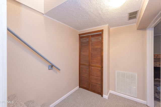 interior space with carpet flooring, a textured ceiling, and crown molding