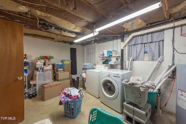 clothes washing area with washer and dryer and water heater