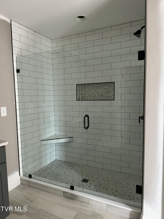 bathroom with vanity and a shower with door