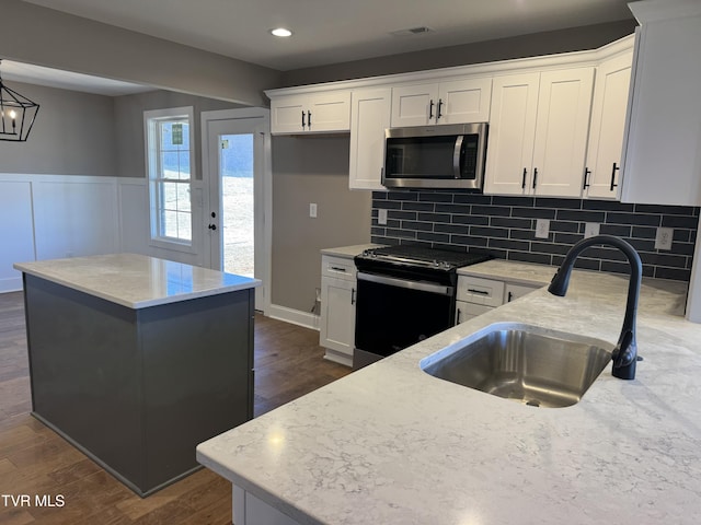 kitchen featuring a center island, sink, and white cabinets