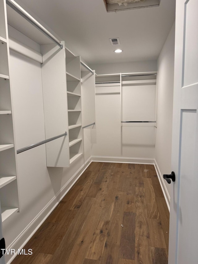 spacious closet with dark hardwood / wood-style flooring