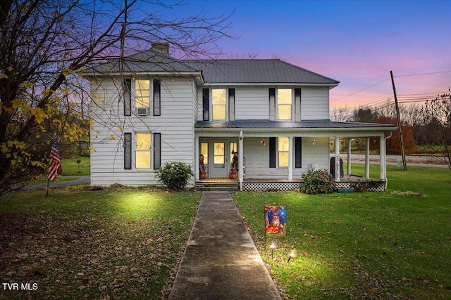 view of front of house featuring covered porch and a yard