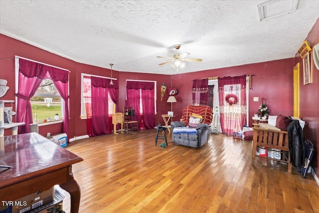 living room featuring a textured ceiling, hardwood / wood-style flooring, and ceiling fan