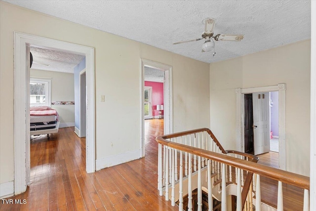 corridor featuring hardwood / wood-style floors and a textured ceiling