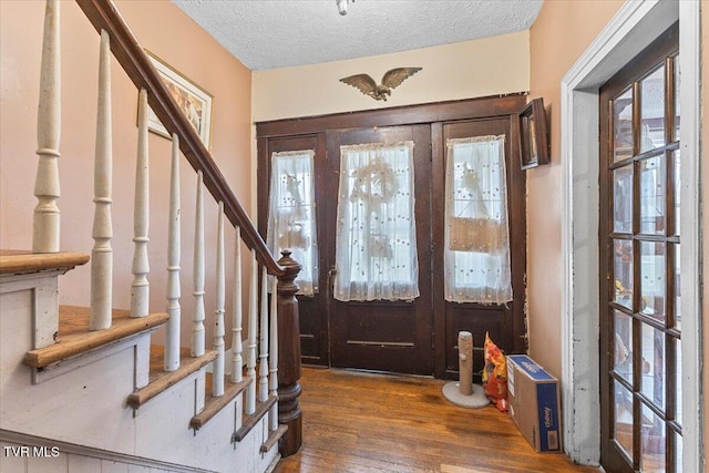 entrance foyer featuring french doors, dark wood-type flooring, and a textured ceiling