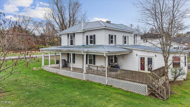 rear view of house featuring a porch and a yard