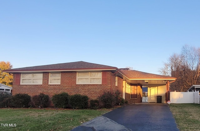 view of front of property featuring a front yard and a carport