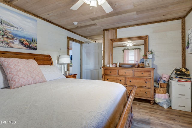 bedroom with ceiling fan, hardwood / wood-style floors, wooden walls, wood ceiling, and ornamental molding