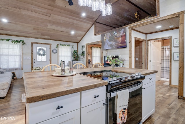 kitchen featuring stainless steel electric stove, a center island with sink, vaulted ceiling, light hardwood / wood-style flooring, and white cabinetry