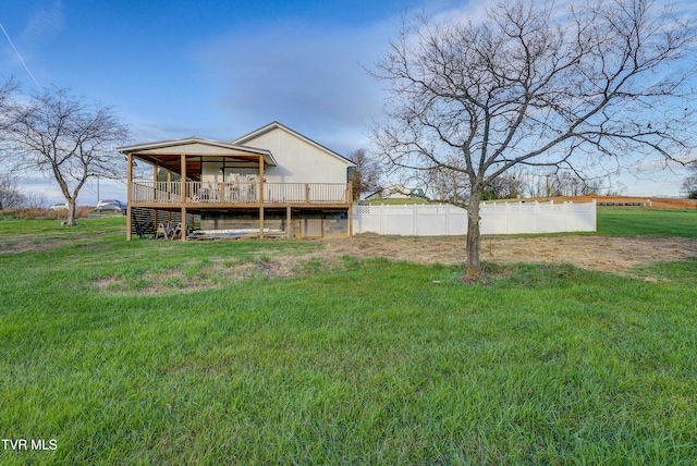 rear view of house featuring a yard and a wooden deck