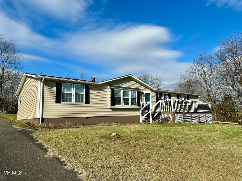 manufactured / mobile home with a deck and a front lawn