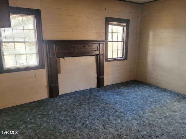 unfurnished living room with a wealth of natural light and carpet