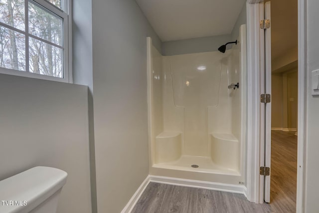 bathroom with a shower, wood-type flooring, and toilet