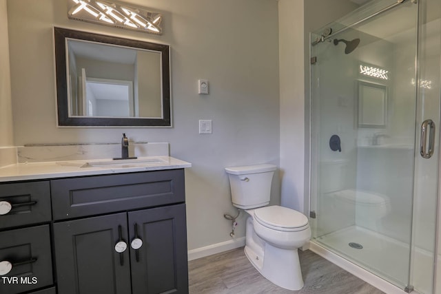 bathroom featuring toilet, vanity, an enclosed shower, and hardwood / wood-style flooring