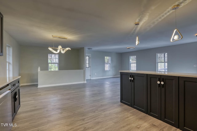 kitchen featuring pendant lighting, dishwasher, a wealth of natural light, and light hardwood / wood-style flooring