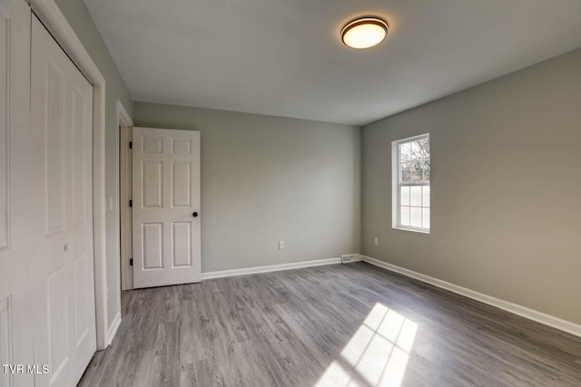 unfurnished bedroom with hardwood / wood-style flooring and a closet