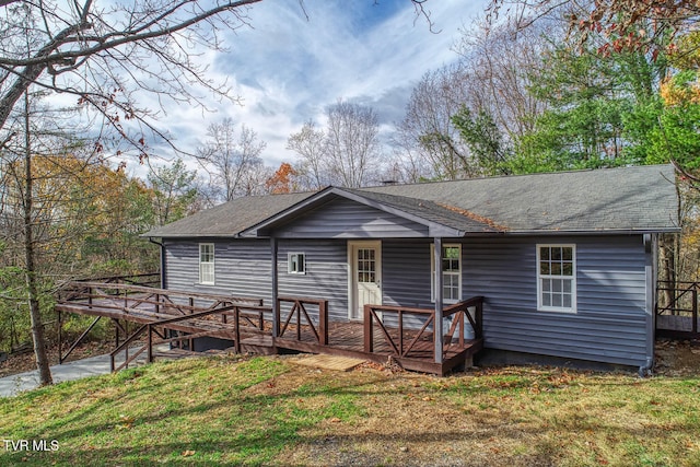 view of front of property with a wooden deck and a front yard