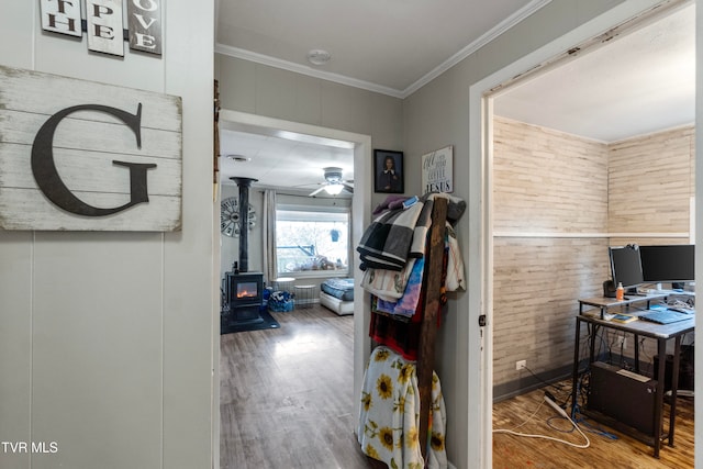 corridor with wood-type flooring, crown molding, and wooden walls