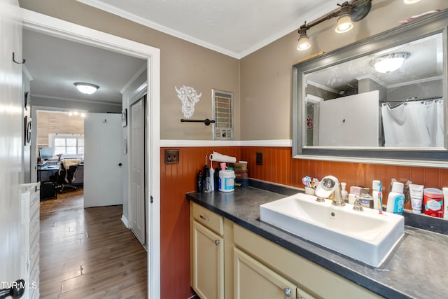 bathroom with hardwood / wood-style floors, vanity, crown molding, and wood walls