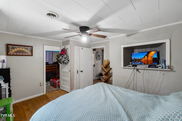 bedroom with hardwood / wood-style flooring, ceiling fan, and ornamental molding