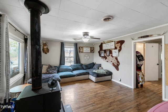 living room featuring a healthy amount of sunlight, crown molding, and dark wood-type flooring