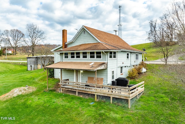 rear view of house featuring a lawn and a wooden deck