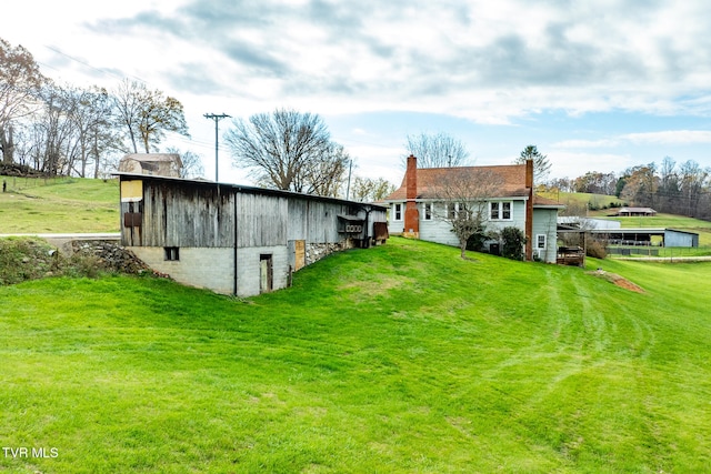 rear view of house with an outbuilding and a lawn