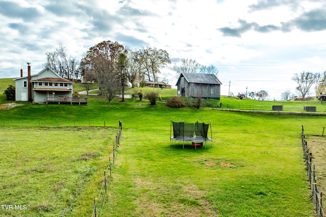 view of yard featuring a rural view and a trampoline