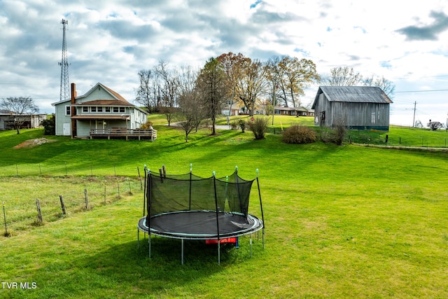 view of yard featuring an outbuilding and a trampoline