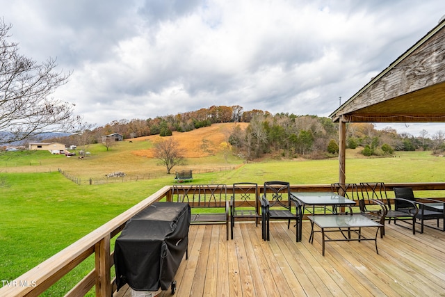 deck featuring a lawn and a rural view