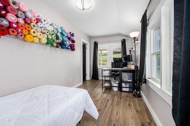 bedroom with wood-type flooring and vaulted ceiling